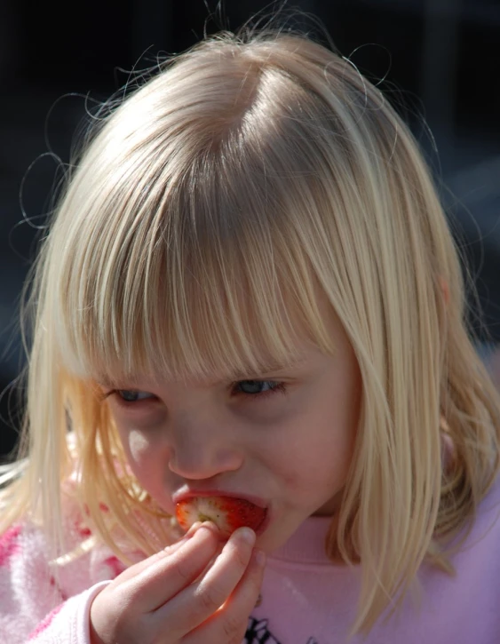 the  is eating an apple and wearing pink