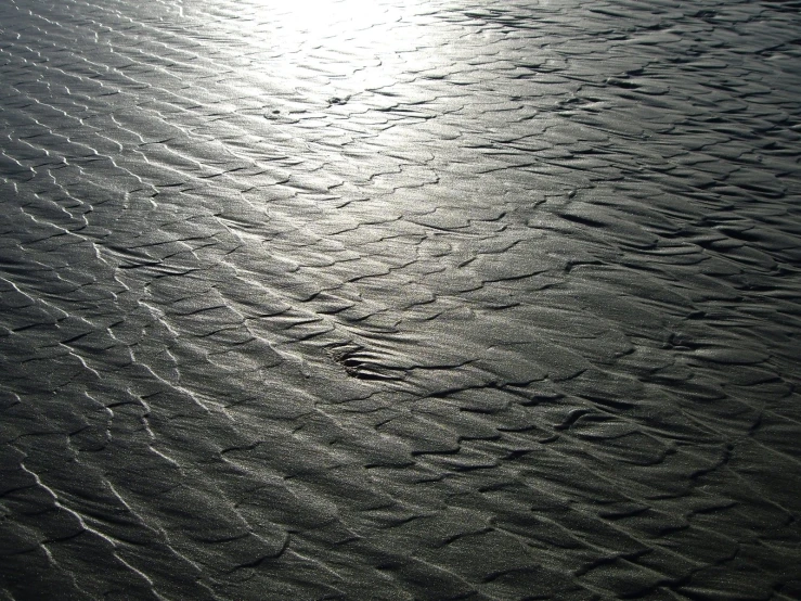 there are some thin lines and waves in the sand