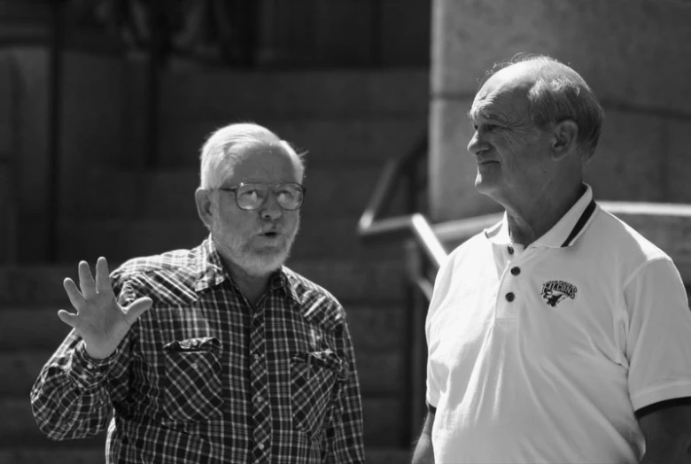 two people in front of a building standing near one another