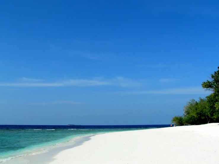 a lone boat is sitting out in the water on a beach