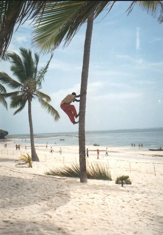 a man jumping into the air on top of a beach