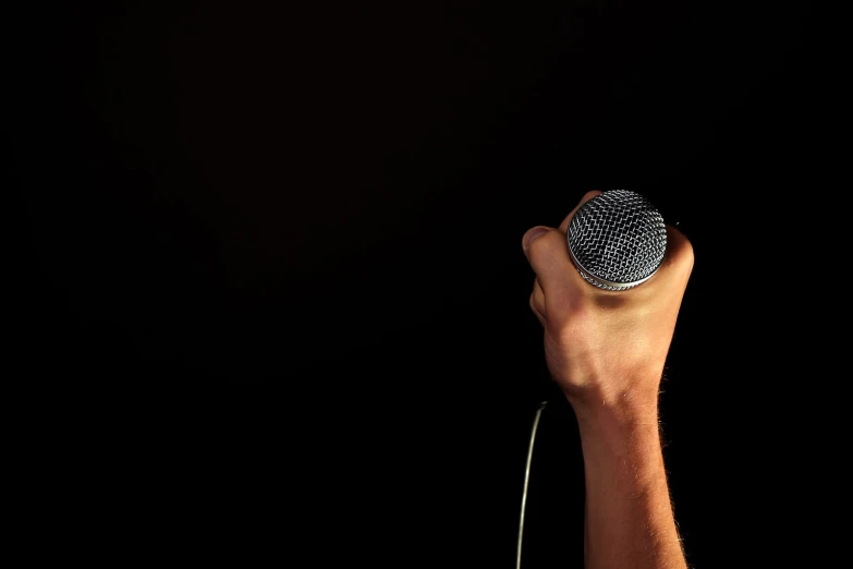a microphone is held up to the black background