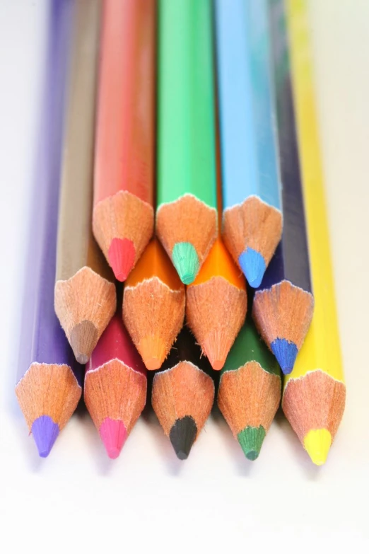 a group of different colored pencils laying on top of each other