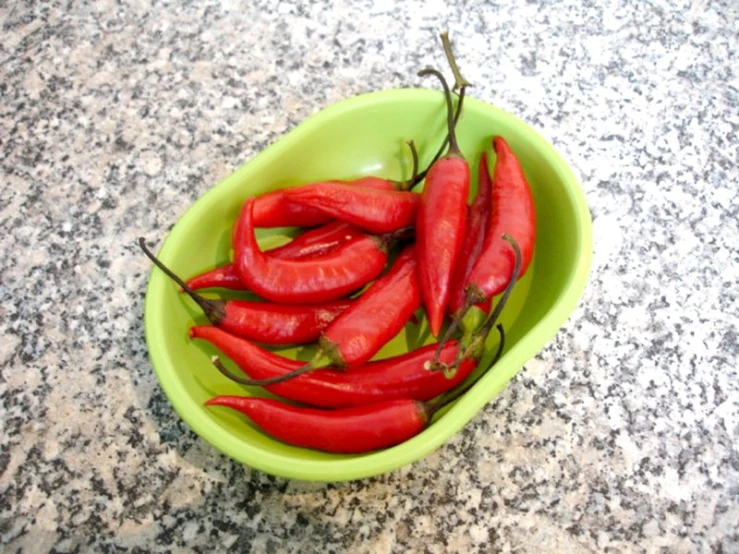 a bowl with red peppers in it sitting on a table