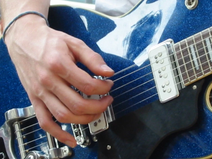 a person is playing on a blue guitar