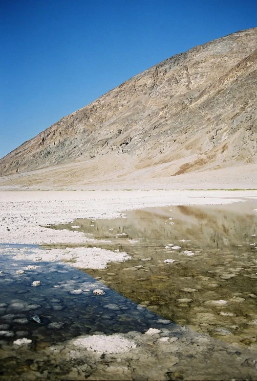 a po taken from the water of a small body of water with mountains in the background