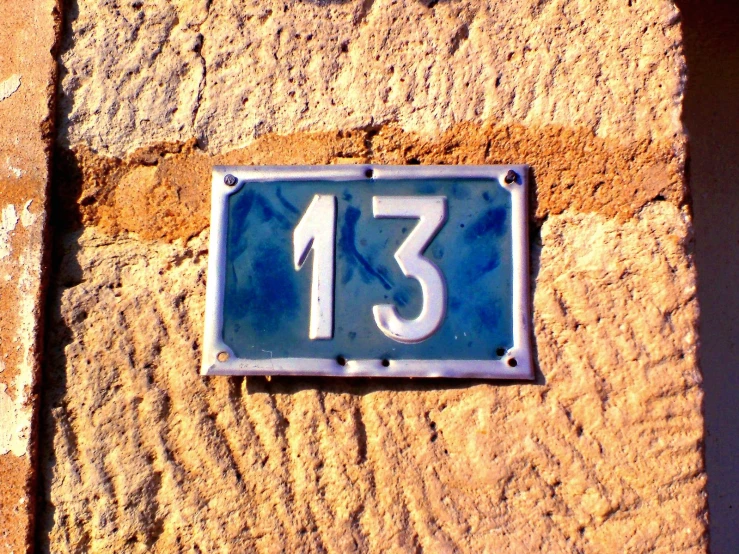a wall with a sign on it with the number thirteen below