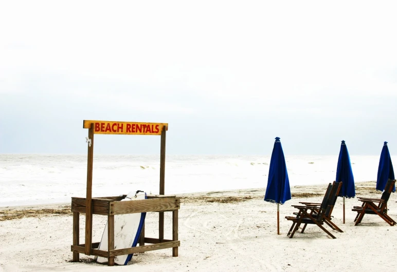 a bunch of lawn chairs that are next to each other on a beach