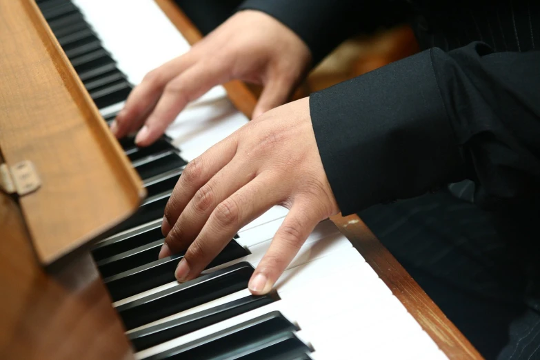 someone is playing on a piano with their hands on the keys