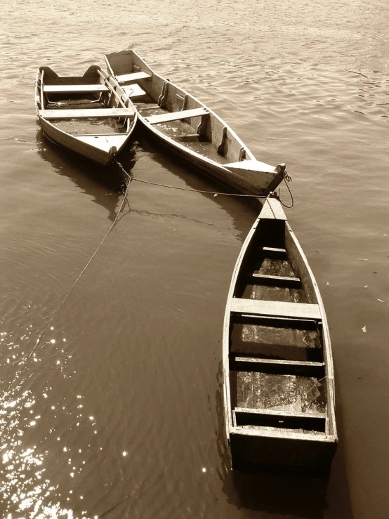 two empty boats tied up in shallow water