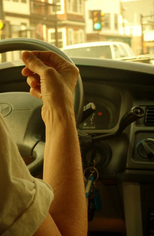 an individual is holding the steering wheel of their vehicle