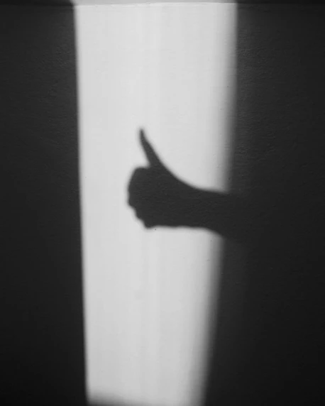 the shadow of a hand on a wall