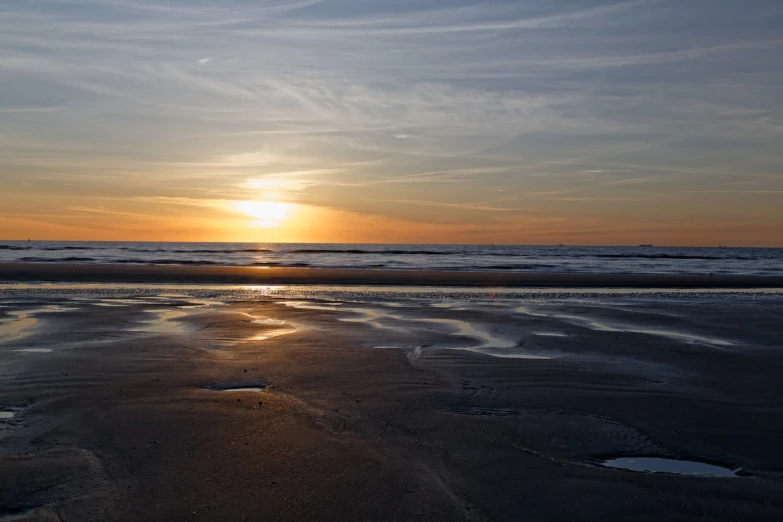 a sandy beach with low tide and waves