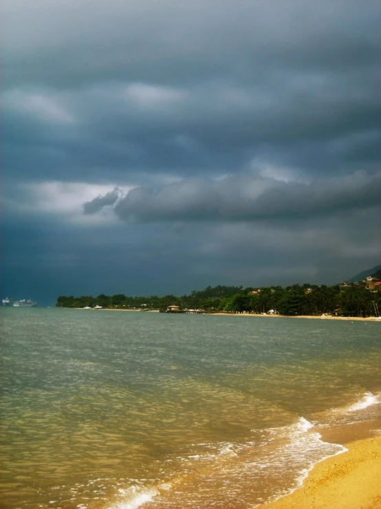 storm clouds over the beach as the tide begins