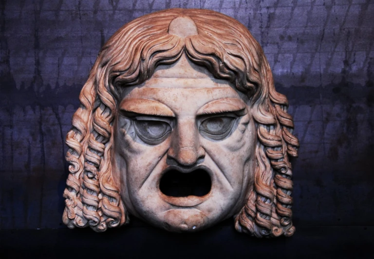 an ornate bust with wavy hair has a screaming face