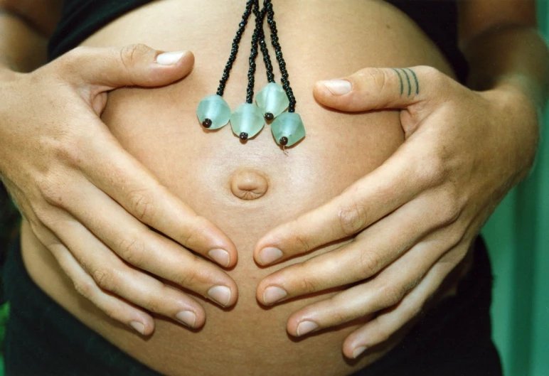 a pregnant woman is shown holding several beads