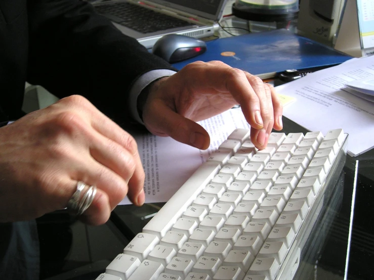 a man using a computer keyboard while sitting at a desk