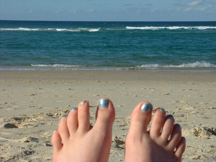 feet that are in the sand at a beach