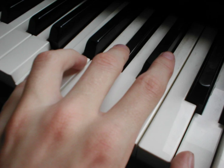 a close up view of someones fingers playing piano