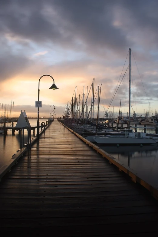 a dock with boats sitting at it in the sunset