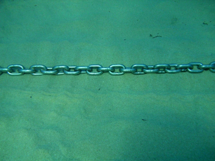 chain of a silver metal object on the ground