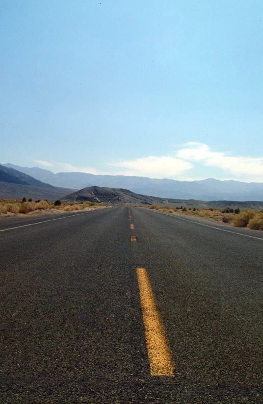 a long open road with mountains in the distance