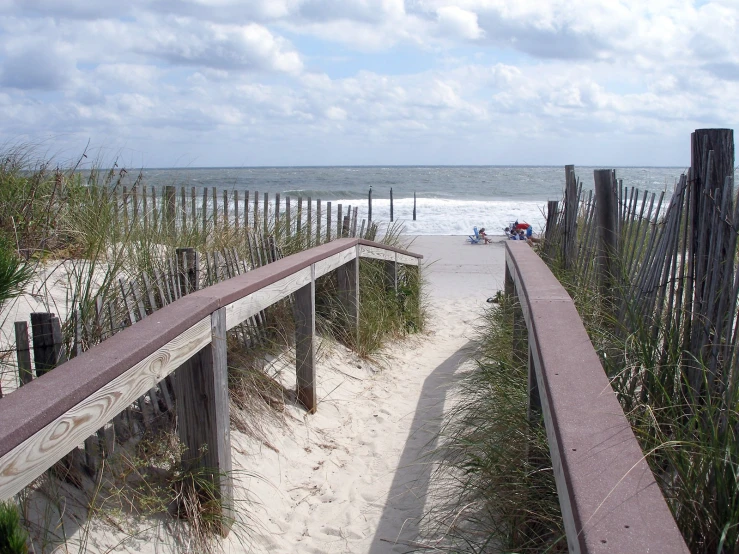 the beach walkway is lined with fences and sand