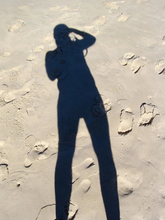 a person is shown on a beach shadow