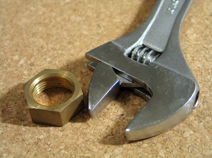 a wrench sitting next to an open nut on the ground