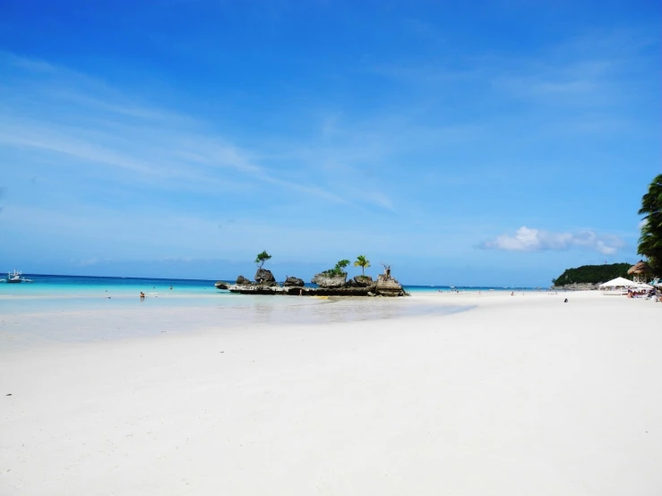 a white beach with palm trees and huts