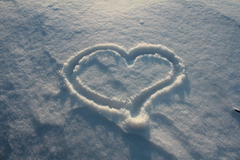 a heart drawn in the snow by a pair of skis