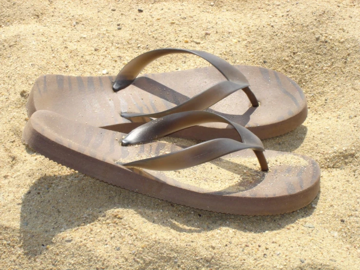 there are three pairs of flip flops laying in the sand