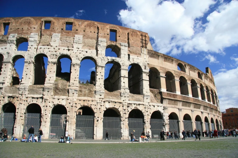 an arena with several large windows sits under a cloudy sky