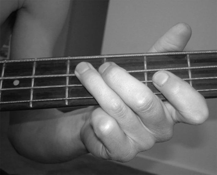 a man is holding a guitar string and pressing