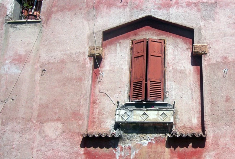 the window is open on the side of an old building