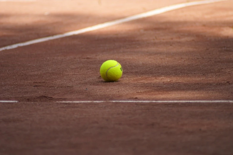 a tennis ball laying on the ground in a court