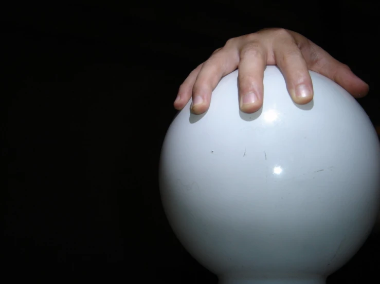 a person's hands on a large ball in the dark