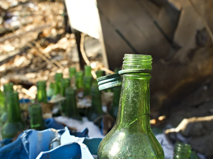 a glass green bottle sitting on top of a table