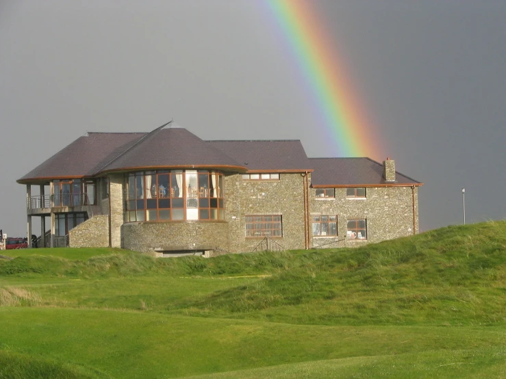 a rainbow is in the distance over a house