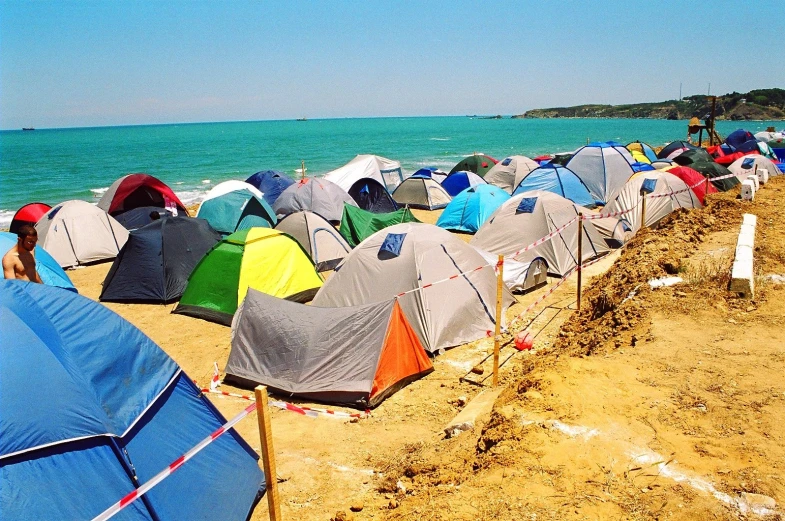 a beach with many tents along the shore