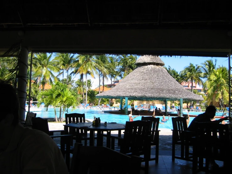 several people sit and relax at tables by the pool