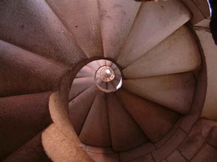a spiral stair with a person standing at the bottom