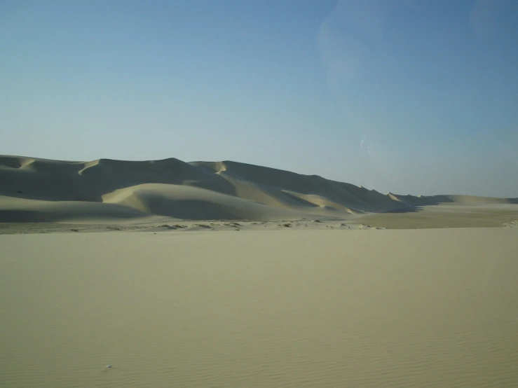 a barren area with sand dunes in the background