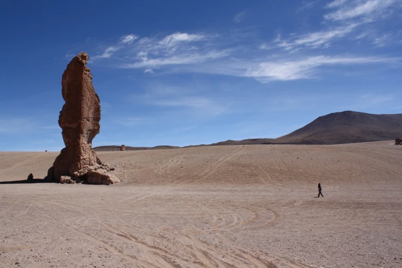 a tall tall rock sitting in the middle of a desert