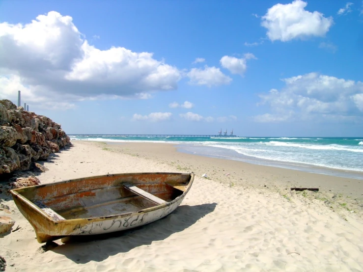 an old boat rests on the beach