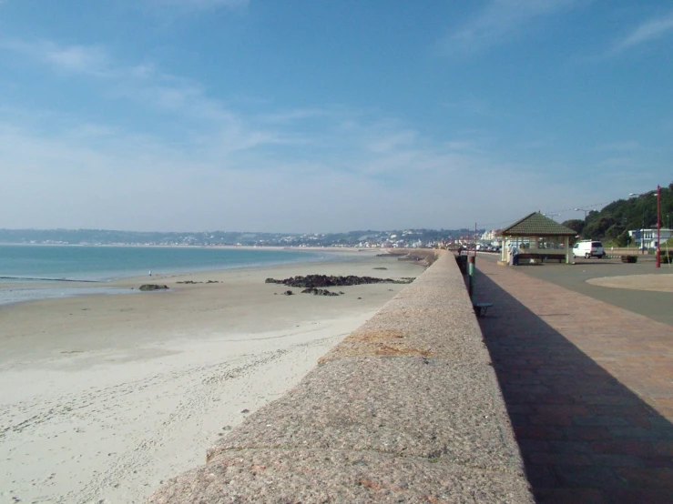 an ocean beach next to the water and houses