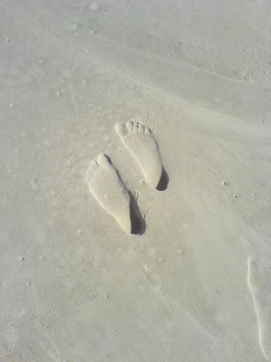 an imprint in the sand on a beach