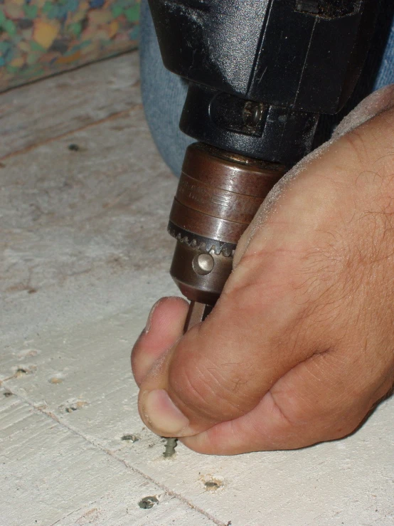 person holding metal tool in the middle of a piece