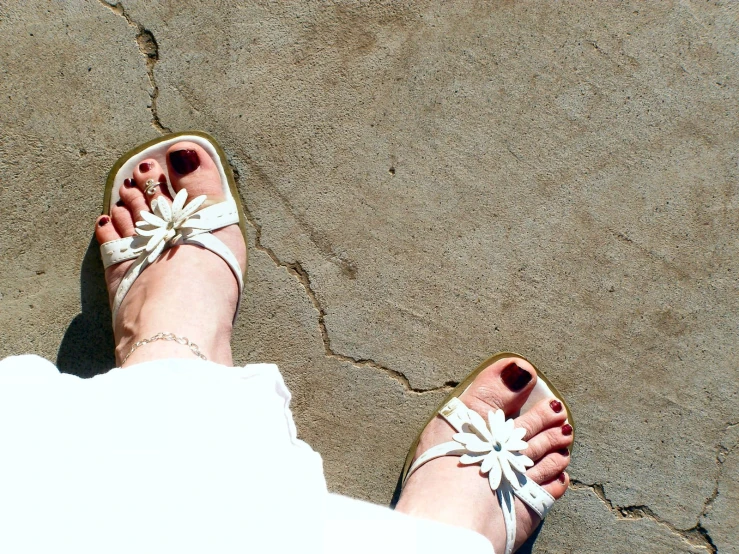 a person in sandals with a bow tie standing on a concrete ground