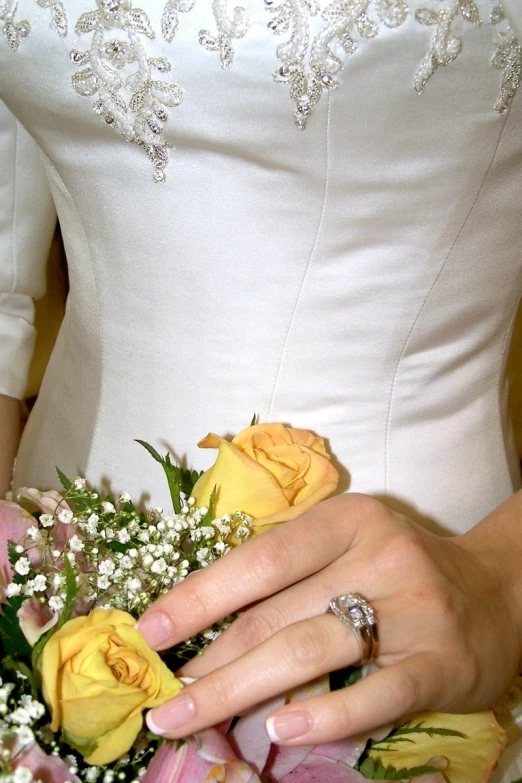 the woman is dressed in white holding flowers